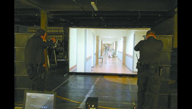 Pulaski County Sheriff’s Deputy Matt Pickens and reserve deputy and jail Sgt. Chris McAninch train with the scenario simulator on Nov. 1. This is the first time they have participated in the scenario with the sheriff’s office.