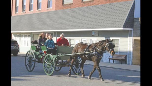 Photo by Megan Galbreath Families enjoyed a quick trip around downtown Francesville in an old fashioned carriage.