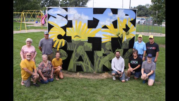 Photo by Paul Hettinger Members of the Pulaski County Tribe and Star City Lions Club celebrate the new artwork that adorns the park. Pictured are (left side front) Don Darda, Kathi Thompson, Brandi Larkin; (back) Lynn Darda, Kevin Larkin; (right side front) Zach Medler, Lenora Hoover, Diana Day; (back) Tom Overmyer and Melvin Good.