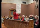 Photo by Megan Galbreath Kathy Wyatt, of Winamac, holds a sign during the Pulaski County Commissioners meeting on March 2 titled, the “Top 5 Counties by Solar Acreage.”